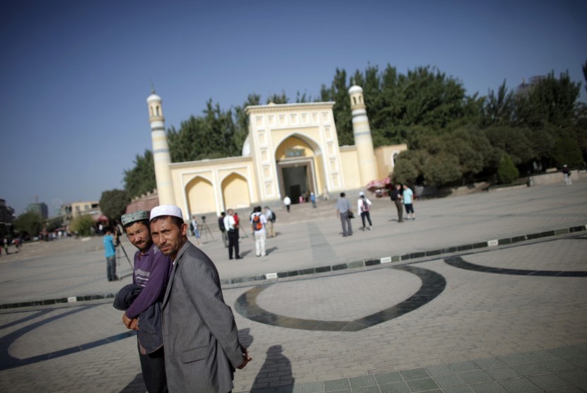 Umat Islam Xinjiang membantah adanya intimadisi umat Islam oleh China Muslim etnis Uighur berjalan di depan sebuah masjid di Kashgar, Xinjiang, Cina.