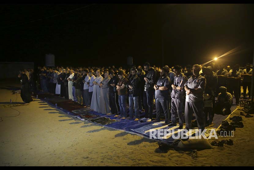 Muslim Gaza melaksanakan Tarawih pertama di lapangan terbuka di perbatasan Gaza dan Israel, Palestina, Rabu (16/5)