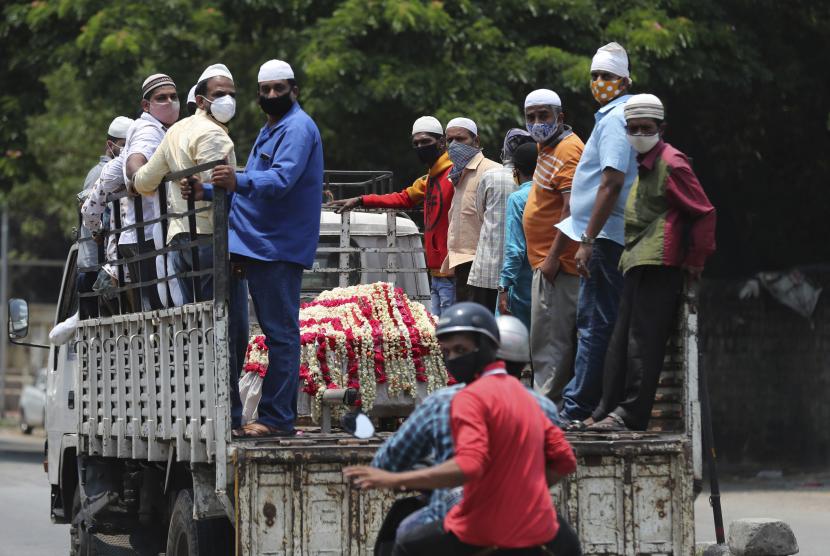 Muslim India yang mengenakan masker wajah sebagai tindakan pencegahan terhadap virus korona mengangkut jenazah seseorang yang meninggal karena alasan non-covid untuk dimakamkan di sebuah pemakaman di Bengaluru, India, Rabu, 28 April 2021.