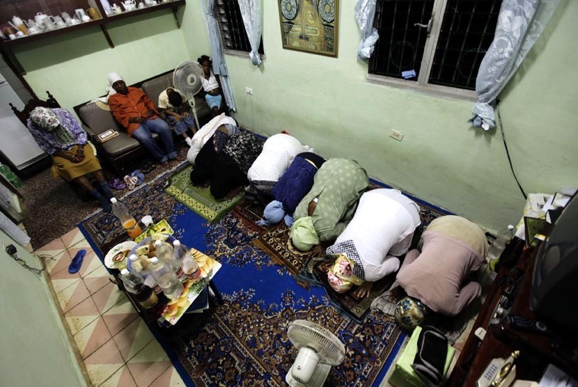   Muslim Kuba shalat Maghrib berjamaah usai makan Iftar atau buka puasa bersama di Havana, Cuba, Jumat (3/8).   (Desmond Boylan/Reuters)