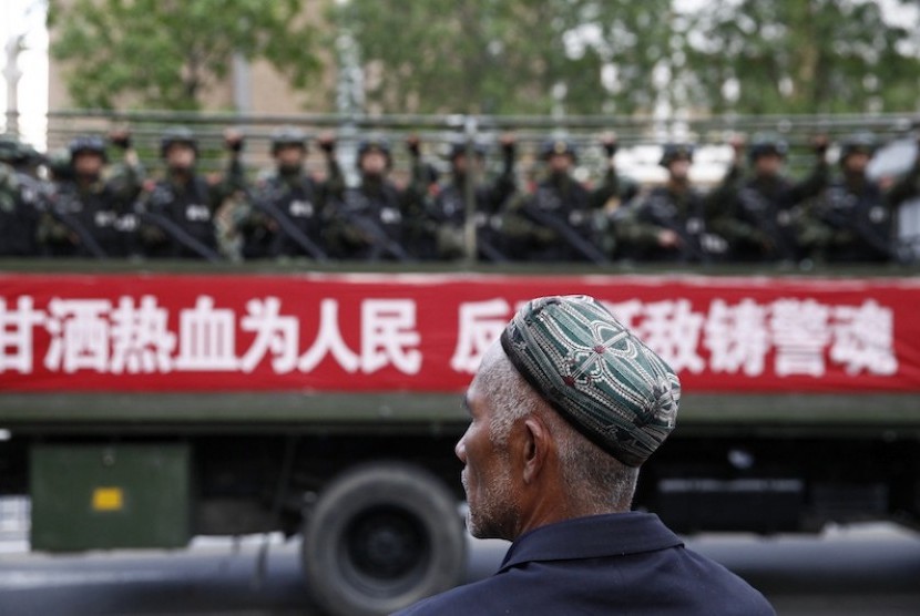Muslim Uighur di depan aparat Cina