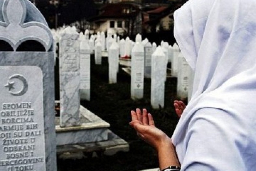 Muslimah berdoa di makam korban genosida Serbia tahun 1995.