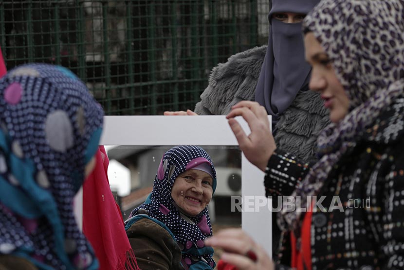 Muslimah Bosnia berkaca setelah mengenakan hijab di sela peringatan World Hijab Day di Sarajevo Bosnia.