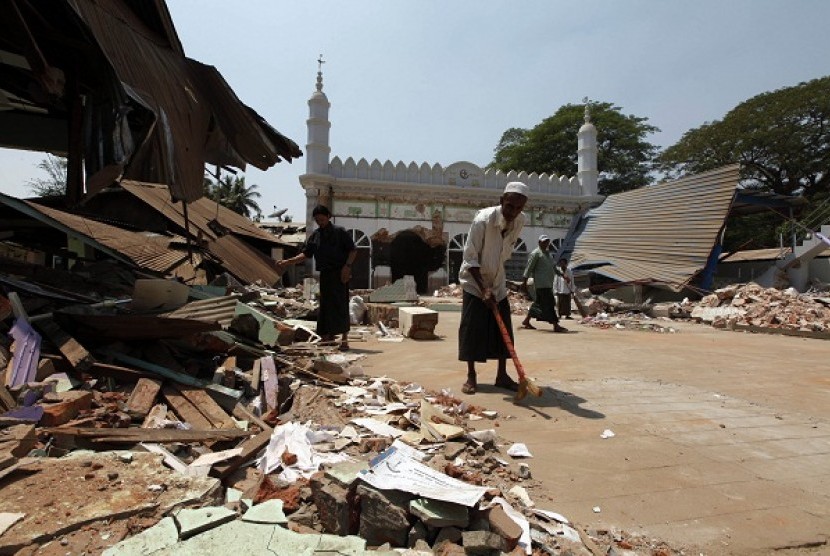 Sekelompok pria Muslim membersihkan puing-puing masjid yang hancur di Gyobingauk, Bago, sekitar 125 mil dari Yangon, Myanmar, Kamis, 28 Maret 2013.