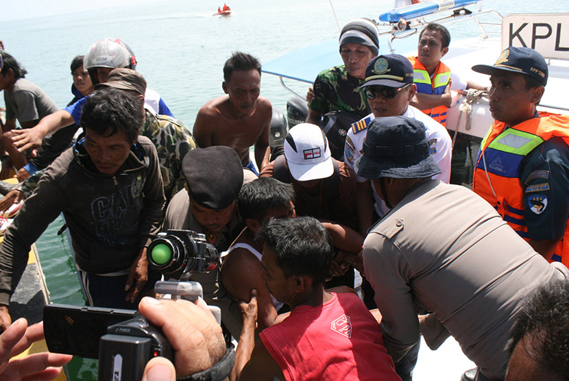 Nahkoda Kapal KM Marina, Asdar (25), menggunakan  kaos oblong tengah dievakuasi dari kapal cepat milik Basarnas, Selasa (22/12). (Republika/Debbie Sutrisno)