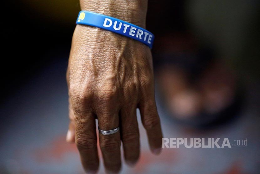 Napi Penjara Quezon City yang akan dilepaskan dari penjara mengenakan gelang karet bertuliskan nama Presiden Filipina, Rodrigo Duterte.