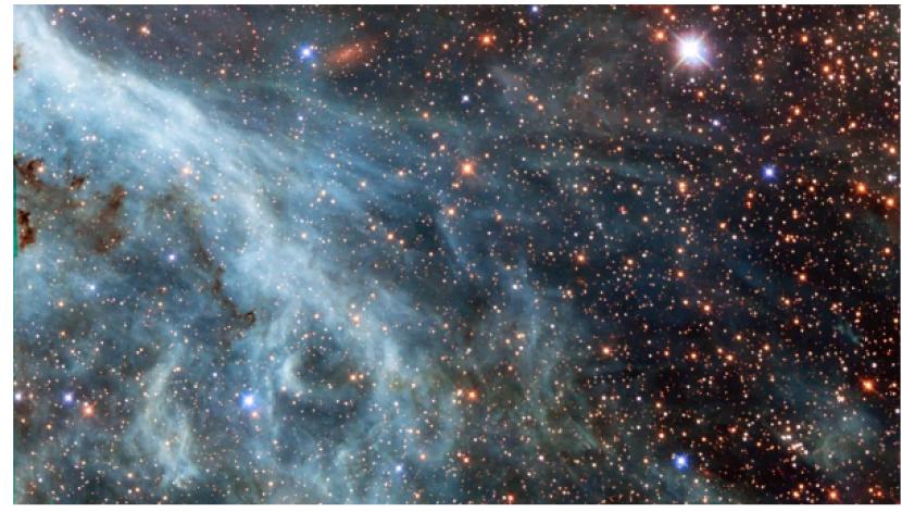 NASA membagikan pemandangan baru Nebula Tarantula. Gambar ini tampak seperti ombak di lautan melalui galaksi pendamping Bima Sakti, Awan Magellan Besar.