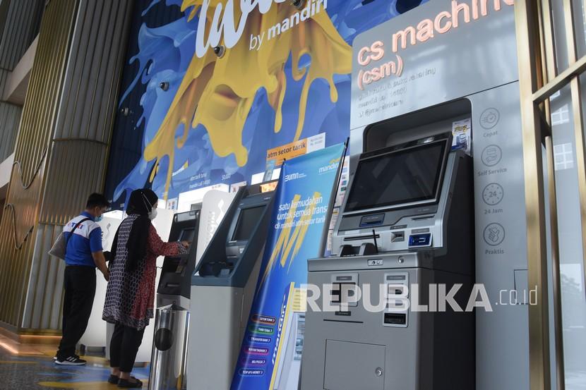 Nasabah bertransaksi melalui mesin anjungan tunai mandiri (ATM) salah satu bank di Jakarta.
