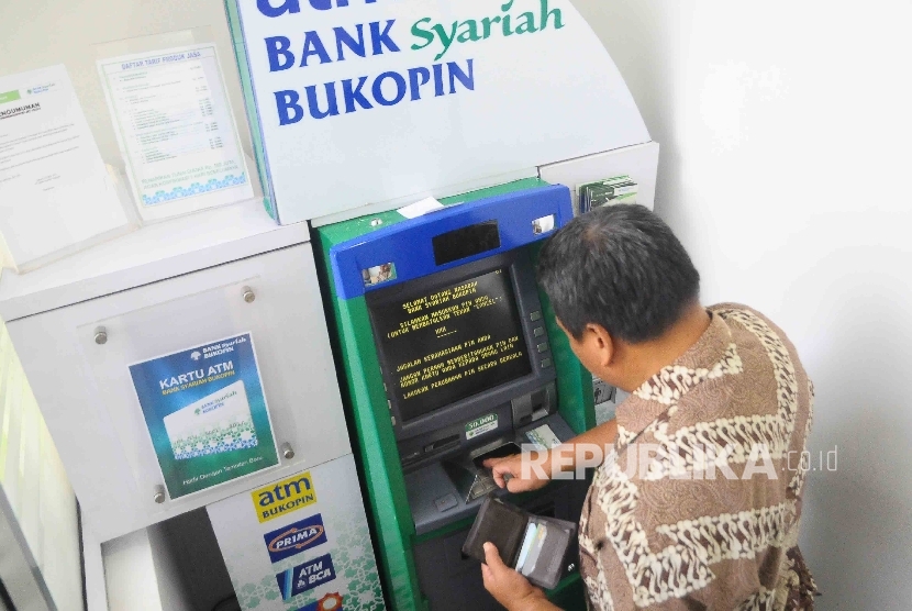 Nasabah melakukan transaksi meggunakan mesin ATM Bank Syariah Bukopin di Jakarta, Ahad (2/10). 