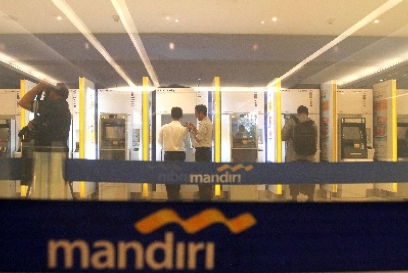 Nasabah melakukan transaksi melalui Anjungan Tunai Mandiri (ATM) Bank Mandiri di Jakarta, Ahad (22/6). 