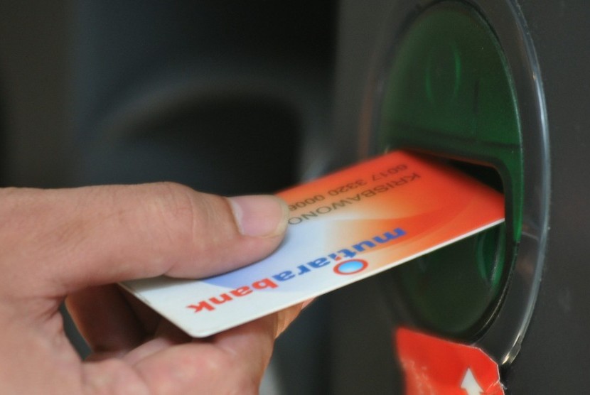 Nasabah melakukan transaksi melalui Anjungan Tunai Mandiri (ATM) Bank Mutiara di Jakarta, Rabu (14/5). 