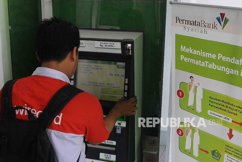 Nasabah melakukan transaksi menggunakan mesin ATM Bank Permata Syariah di Jakarta, Ahad (27/11).