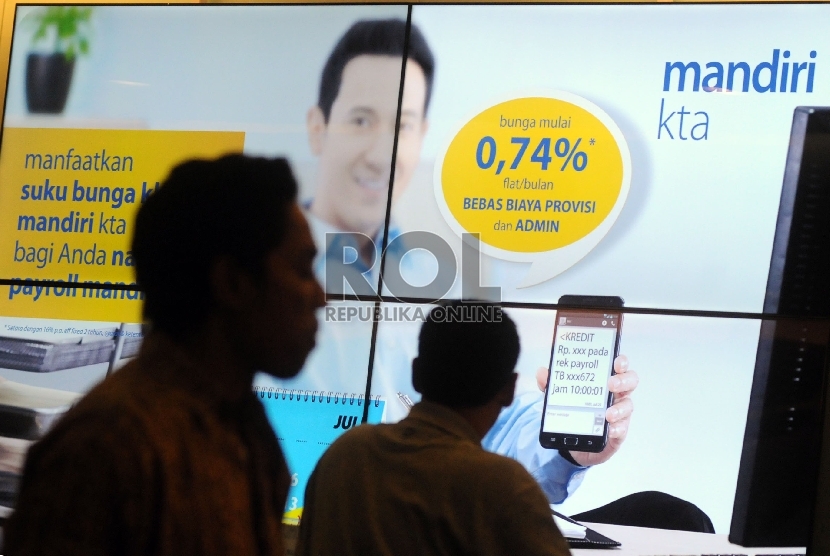Nasabah melintasi banner iklan penawaran kredit tanpa agunan (KTA) yang ditawarkan di salah satu kantor cabang Bank Mandiri, Jakarta, Jumat (13/9). 