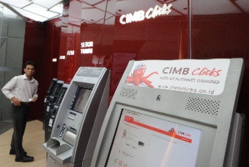 Nasabah mengambil uangnya dari mesin anjungan tunai mandiri (ATM) di salah satu kantor cabang Bank CIMB Niaga, Jakarta, Jumat (21/6). 