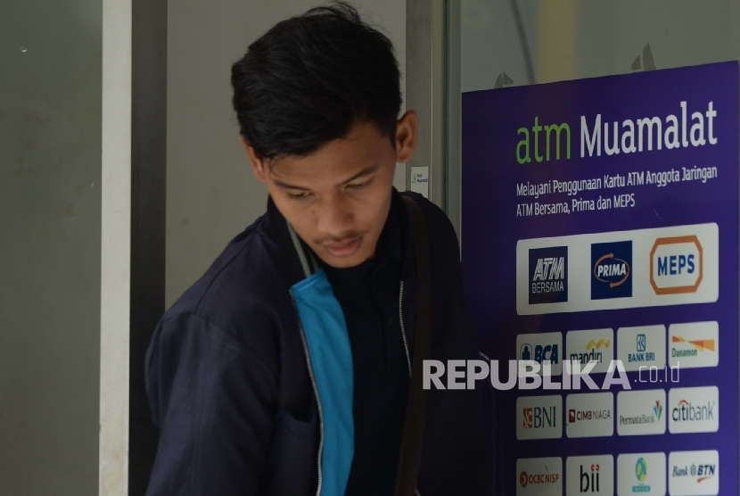  Nasabah menggunakan anjungan tunai mandiri (ATM) Bank Muamalat di Jakarta, Ahad (16/4). 