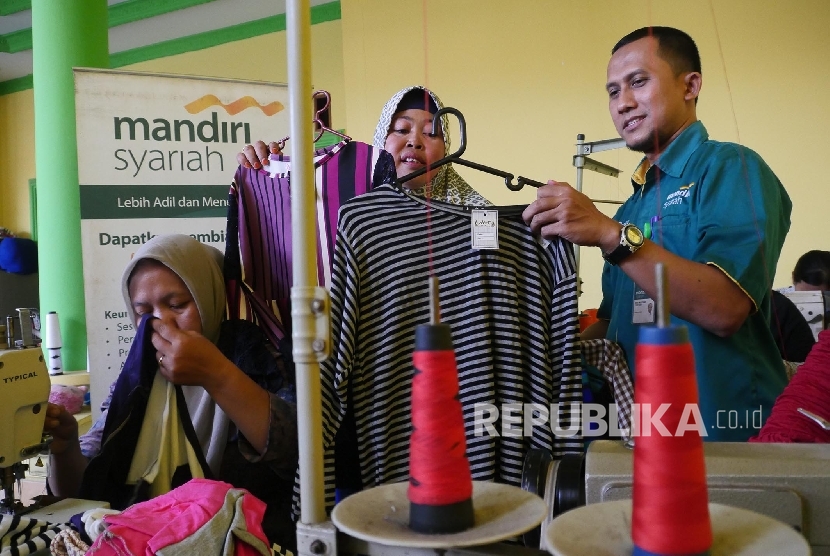  Nasabah Usaha Mikro Kecil dan Menengah (UMKM) Bank Mandiri Syariah Sumairah (kiri) memperlihatkan produknya kepada Pegawai Retail Sales Executive Mandiri Syariah saat meninjau workshopnya di Citeureup Bogor, Jawa Barat, Rabu (13/9). 