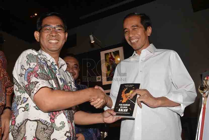   Pemimpin Redaksi Harian Republika, Nasihin Masha memberikan buku 'Perjuangan Melawan Kalah' kepada Presiden terpilih, Joko Widodo saat peluncuran buku tersebut di Jakarta, Selasa (2/9). (Republika/Agung Supriyanto)