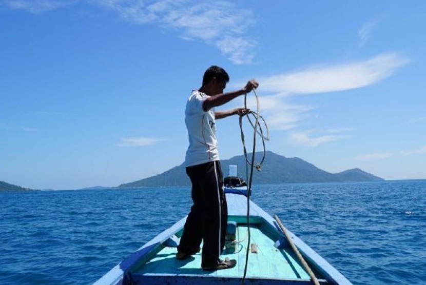 Nelayan bernama Idris (42) di atas perahunya di perairan Kepulauan Natuna.