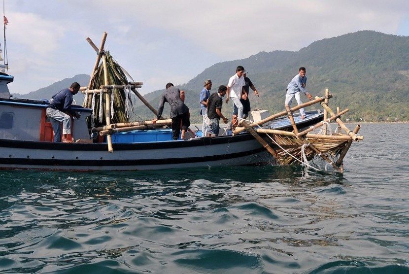Nelayan bersama LSM peduli lingkungan, Yayasan Lamjabat dan Jaringan Kuala melepaskan rumpon terbuat dari bambu dan daun kelapa di peraian Ujung Pancu, Aceh Besar, Aceh, Selasa (3/3). 