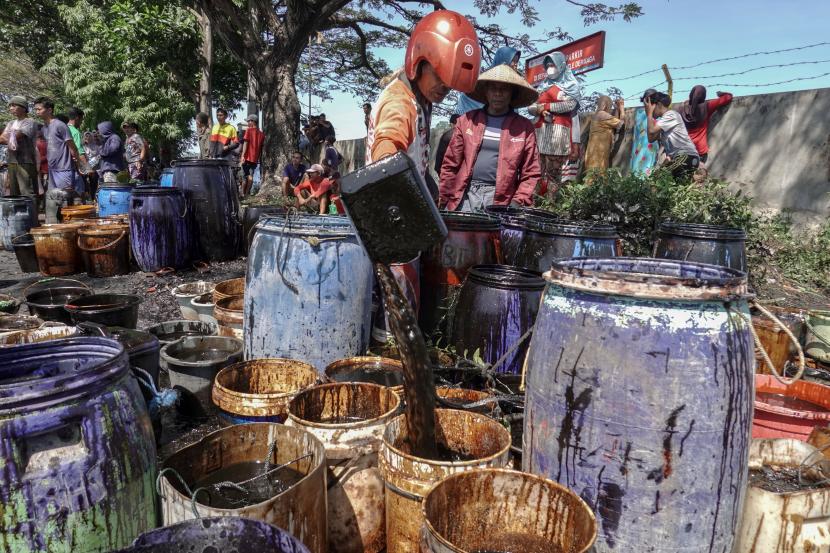 Nelayan dan warga mengumpulkan tumpahan minyak mentah yang menggenangi perairan sekitar Dermaga Wijayapura dan Area 70 Cilacap, Jateng, Selasa (28/6/2022). PT Kilang Pertamina Internasional Unit Cilacap bersama nelayan dan warga melakukan pembersihan tumpahan minyak mentah yang diketahui pertama kali pada Senin (27/6/2022) sore.