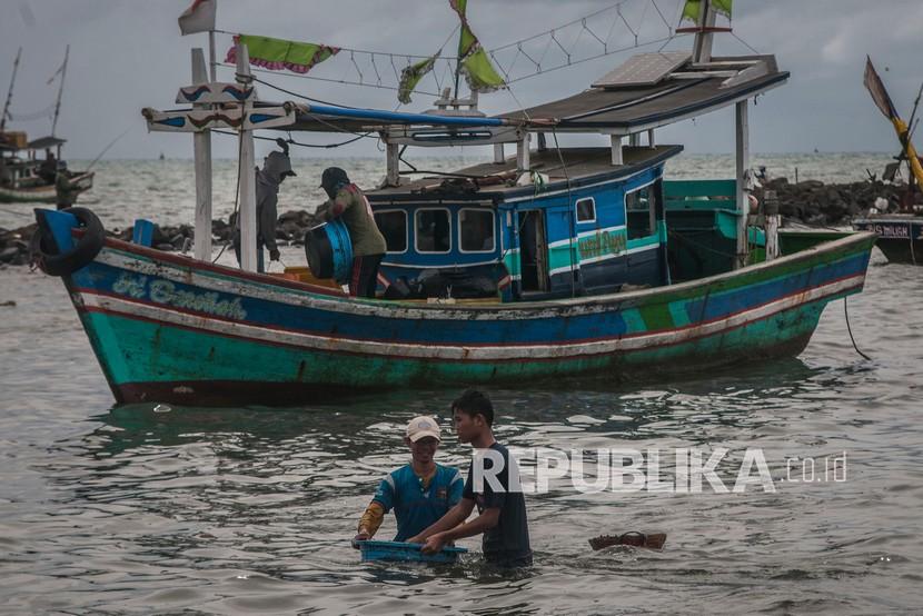 Nelayan membawa ikan hasil tangkapannya di Teluk Labuan, Kabupaten Pandeglang, Banten, Selasa (14/12/2021). 
