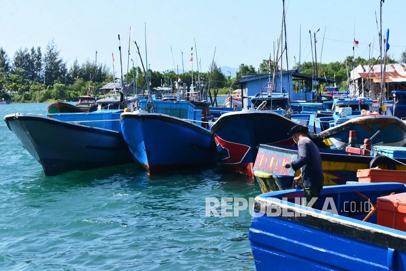 Nelayan memperbaiki kapal saat sandar di pelabuhan perikanan Desa Lambung, Kecamatan meuraxa, Banda Aceh, Aceh, Sabtu (17/7/2021). Sebagian nelayan di daerah itu mulai libur melaut dalam rangka menyambut perayaan tradisi meugang (hari memotong ternak) menjelang Hari Raya Idul Adha.