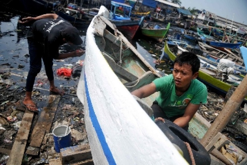 Nelayan mengecat perahu di Permukiman Nelayan Cilncing, Jakarta, Rabu (11/6). 