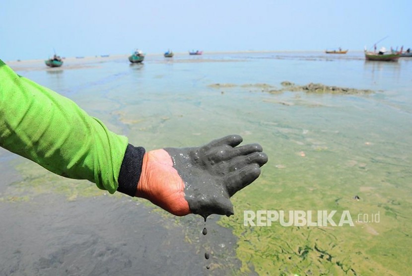 Nelayan menunjukkan lumpur hitam yang mencemari kawasan pantai (ilustrasi)
