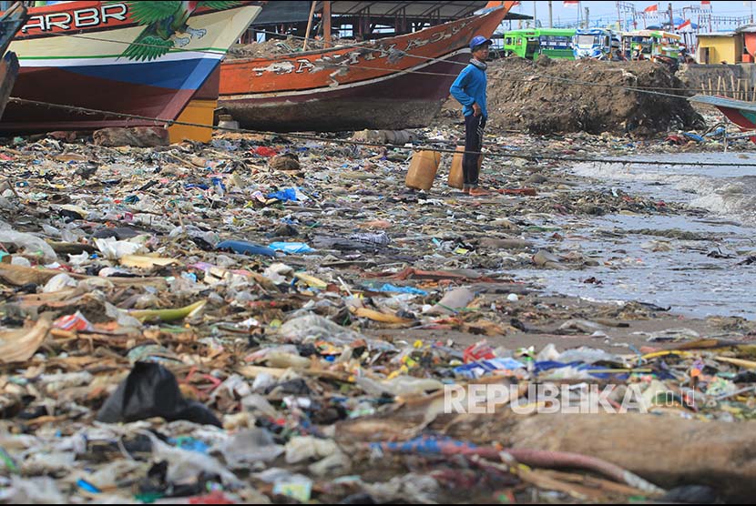 Nelayan menyandarkan perahunya di bibir pantai yang dipenuhi sampah plastik di Desa Dadap, Indramayu, Jawa Barat, Senin (26/11/2018). LSM World Wild Fund for Nature (WWF) Indonesia menilai masalah pencemaran sampah plastik di laut Indonesia sangat parah.