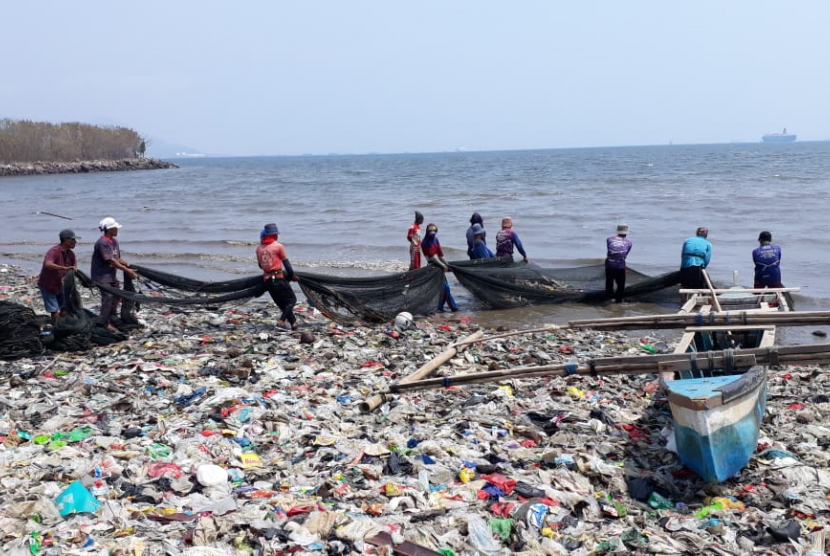 Nelayan payang usai menebar jaring di tengah laut lalu ditarik talinya dari darat beramai-ramai ke pantai, terganggu dengan banyaknya sampah di Teluk Lampung.