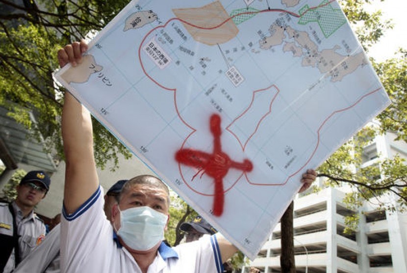Nelayan Taiwan Pan Chiu-chung mengacungkan peta dengan tanda merah dimana kapal putranya ditahan penjaga pantai Jepang. Pan melakukan protes di luar kantor perwakilan Jepang di Taipei, Taiwan, 27 April 2016.