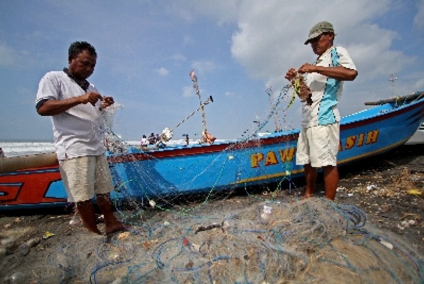 Nelayan tradisional membenahi jaring (ilustrasi).