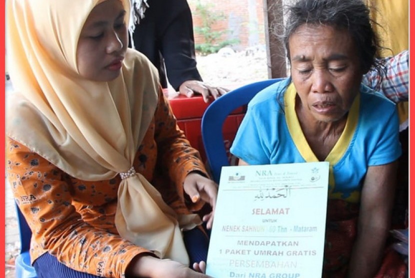 Nenek  Sahnun (kanan) menerima voucher hadiah umrah gratis yang diserahkan oleh staf NRA Mataram.