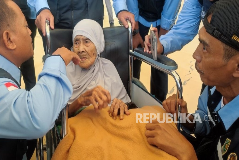 Nenek Sumbuk bersama dengan para petugas haji yang menyambutnya di Terminal Haji Bandara Internasional King Abdul Aziz Jeddah, Arab Saudi, Ahad (18/5/2025).