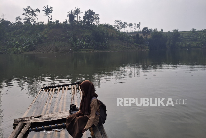  Nera Nur Puspita (16), Siswa Asal Kampung Cipeundeuy RT 03/04, Desa Jati, Kecamatan Saguling, Kabupaten Bandung Barat, Jawa Barat tengah naik rakit menuju sekolah.
