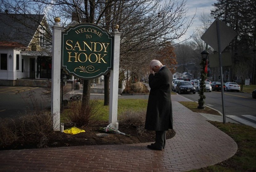 New Jersey resident Steve Wruble, who was moved to drive out to Connecticut to support local residents, grieves for victims of an elementary school mass shooting at the entrance to Sandy Hook village in Newtown, Connecticut December 15.  