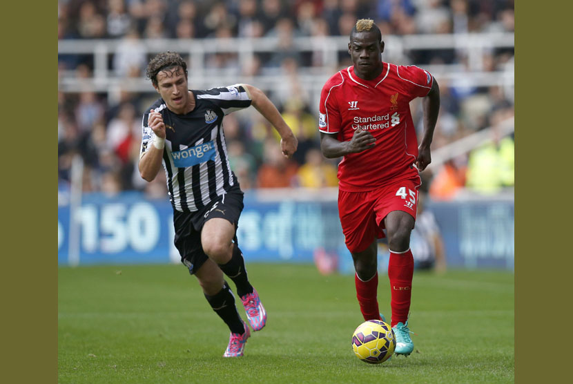 Newcastle United's Daryl Janmaat (L) challenges Liverpool's Mario Balotelli during their English Premier League soccer match at St James' Park in Newcastle, northern England November 1, 2014