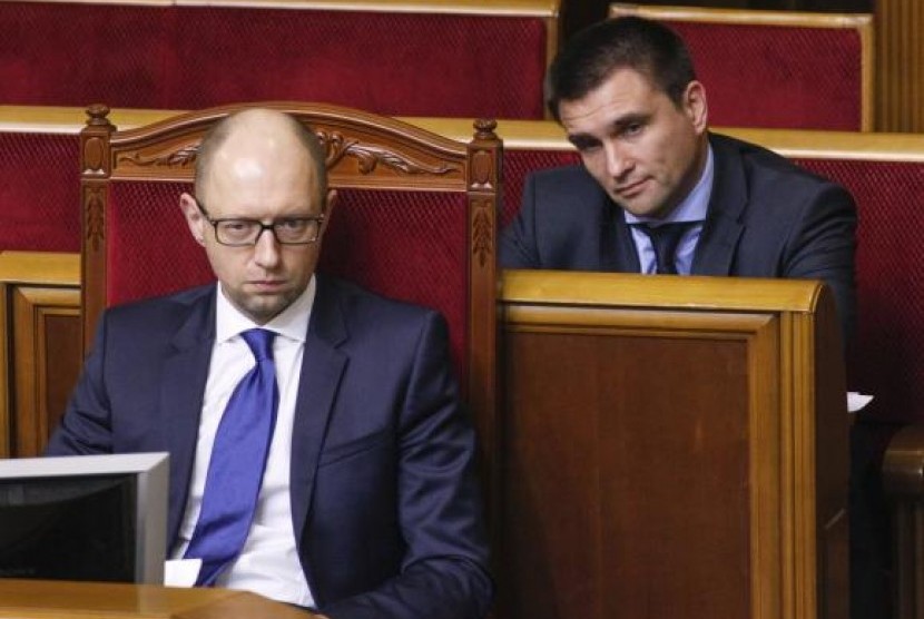 Newly appointed Foreign Minister Pavlo Klimkin (R) and Prime Minister Arseny Yatseniuk listen to Ukrainian President Petro Poroshenko (not pictured) during a session of parliament in Kiev December 2, 2014. 