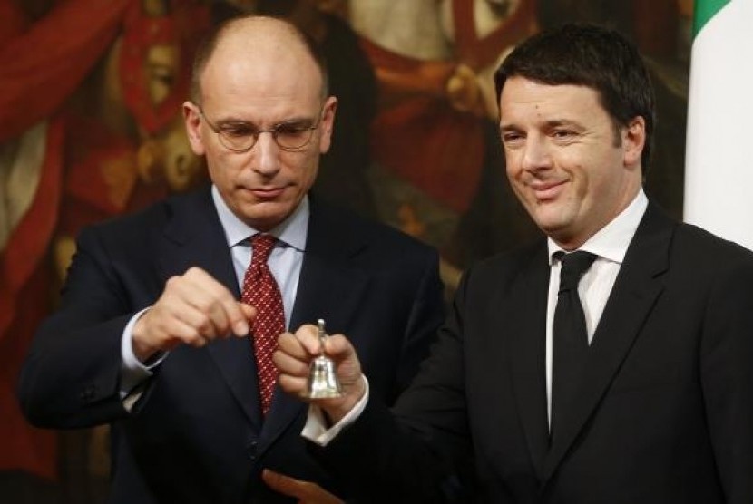 Newly appointed Italian Prime Minister Matteo Renzi (right) rings a silver bell to signify the start of his first cabinet meeting, next his predecessor Enrico Letta, at Chigi Palace in Rome on February 22, 2014. 
