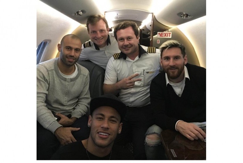 Neymar (bawah) bersama Lionel Messi (kanan) dan Javier Mascherano (kiri) dalam jet.
