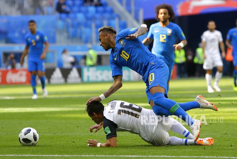 Neymar terjatuh saat berebut bola dengan pemain kosta Rika Cristian Gamboa pada pertandingan grup E Piala Dunia  di St Petersburg Stadium di St. Petersburg, Rusia, Jumat (22/6). 