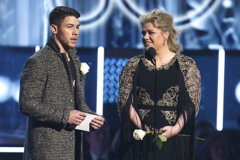 Nick Jonas dan Kelly Clarkson membawa mawar putih saat membacakan nominasi di Grammy Awards, Senin (29/1).