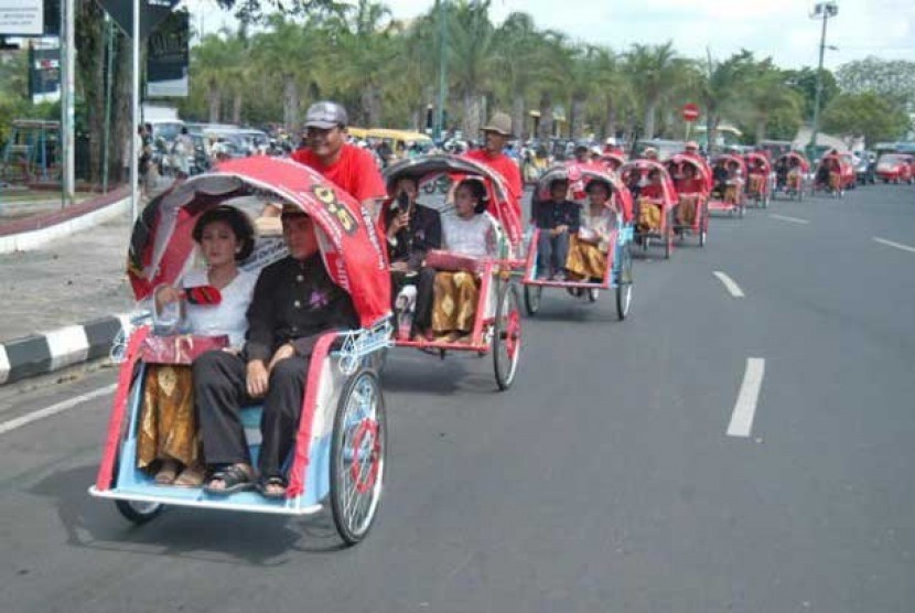 Sejumlah pasangan pengantin diarak menggunakan becak setelah mengikuti nikah massal.