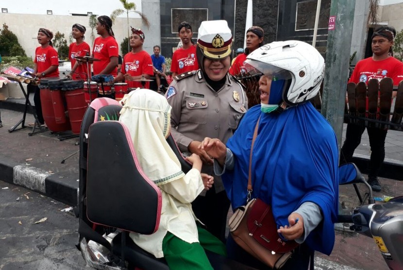 Ning (berkerudung biru) bersama anaknya, Asyifa, ketika berpamitan kepada petugas Direktorat Lalu Lintas Polda DI Yogkarta, Senin (25/9) hari ini. Ditlantas Polda DIY membagikan 1.000 helm bagi pengendara kendaraan bermotor yang membawa anak-anak. 