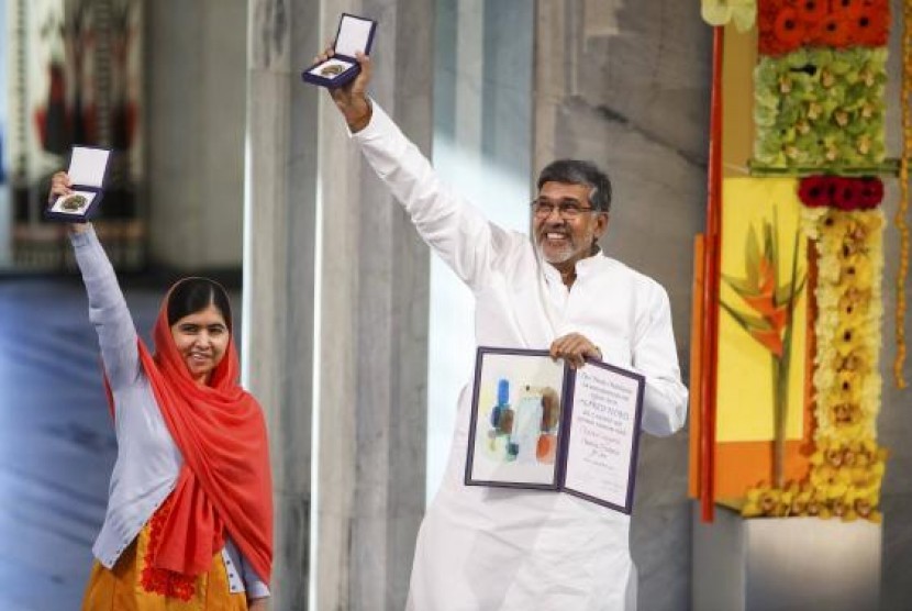 Nobel Peace Prize laureates Malala Yousafzai and Kailash Satyarthi (R) pose with their medals during the Nobel Peace Prize awards ceremony at the City Hall in Oslo December 10, 2014.