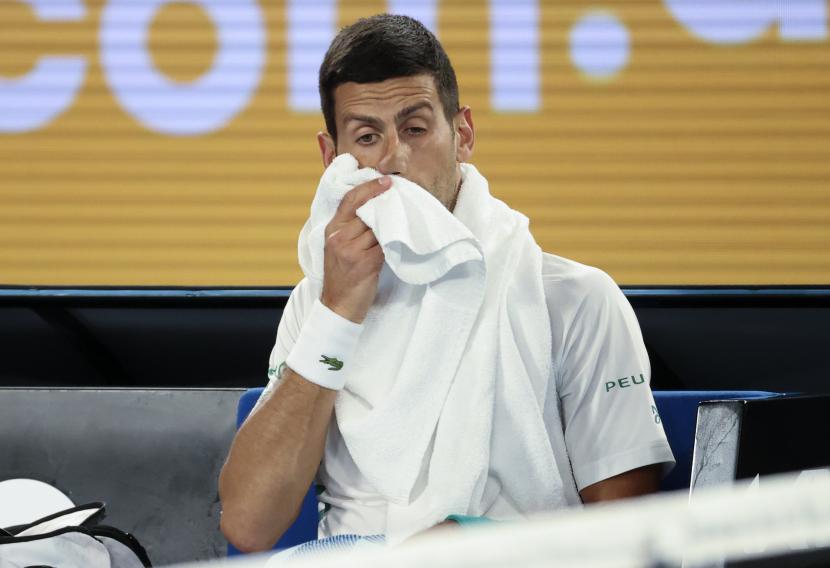 Novak Djokovic dari Serbia menyeka wajahnya saat istirahat dalam pertandingan putaran keempat melawan Milos Raonic dari Kanada pada kejuaraan tenis Australia Terbuka di Melbourne, Australia, Minggu, 14 Februari 2021.