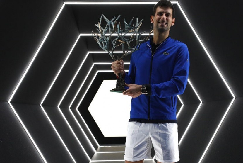 Novak Djokovic memegang trofi juara Paris Masters 2019.