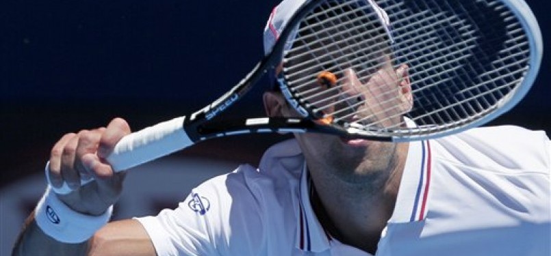 Novak Djokovic, petenis asal Serbia, melepaskan pukulan forehand saat menghadapi petenis Italia, Paolo Lorenzi, di putaran pertama turnamen Australia Terbuka di Melbourne, Australia, Selasa (17/1). 
