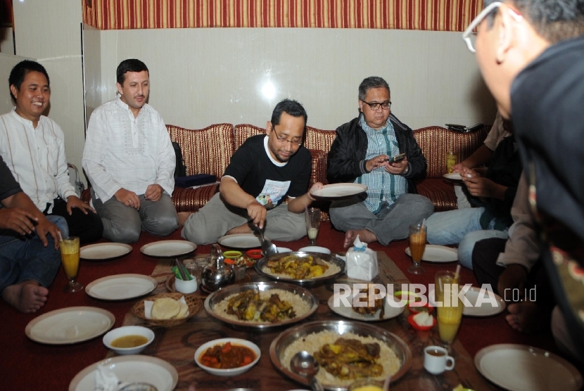 Novelis Habiburahman Al Shirazy menyendok nasi kebuli pada acara syukuran atas novelnya yang berjudul Ketika Cinta Bertasbih mendapatkan penghargaan di Turki pada Nopember lalu, di Jakarta, Jumat (18/3).