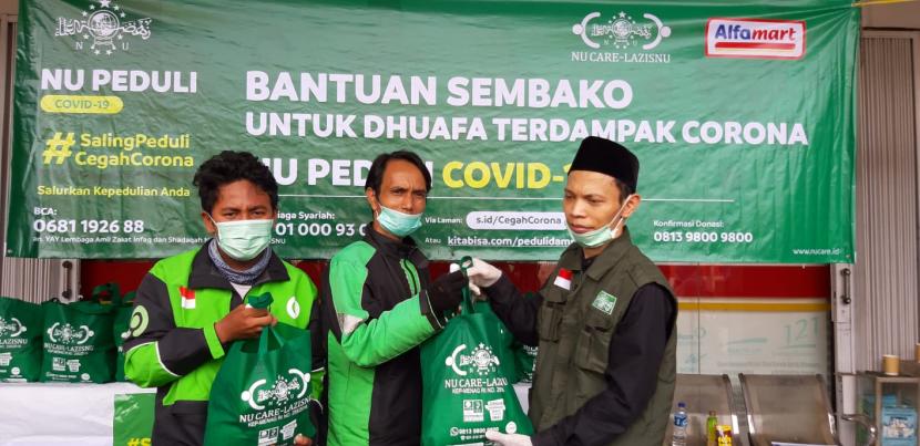  NU Care Lazisnu mendistribusikan paket sembako untuk kaum dhuafa yang terkena dampak pandemi virus Corona atau Covid-19 di Gerai Alfamart, Jalan Moh Kahfi I, Ciganjur, Jakarta Selatan, Kamis (2/4).